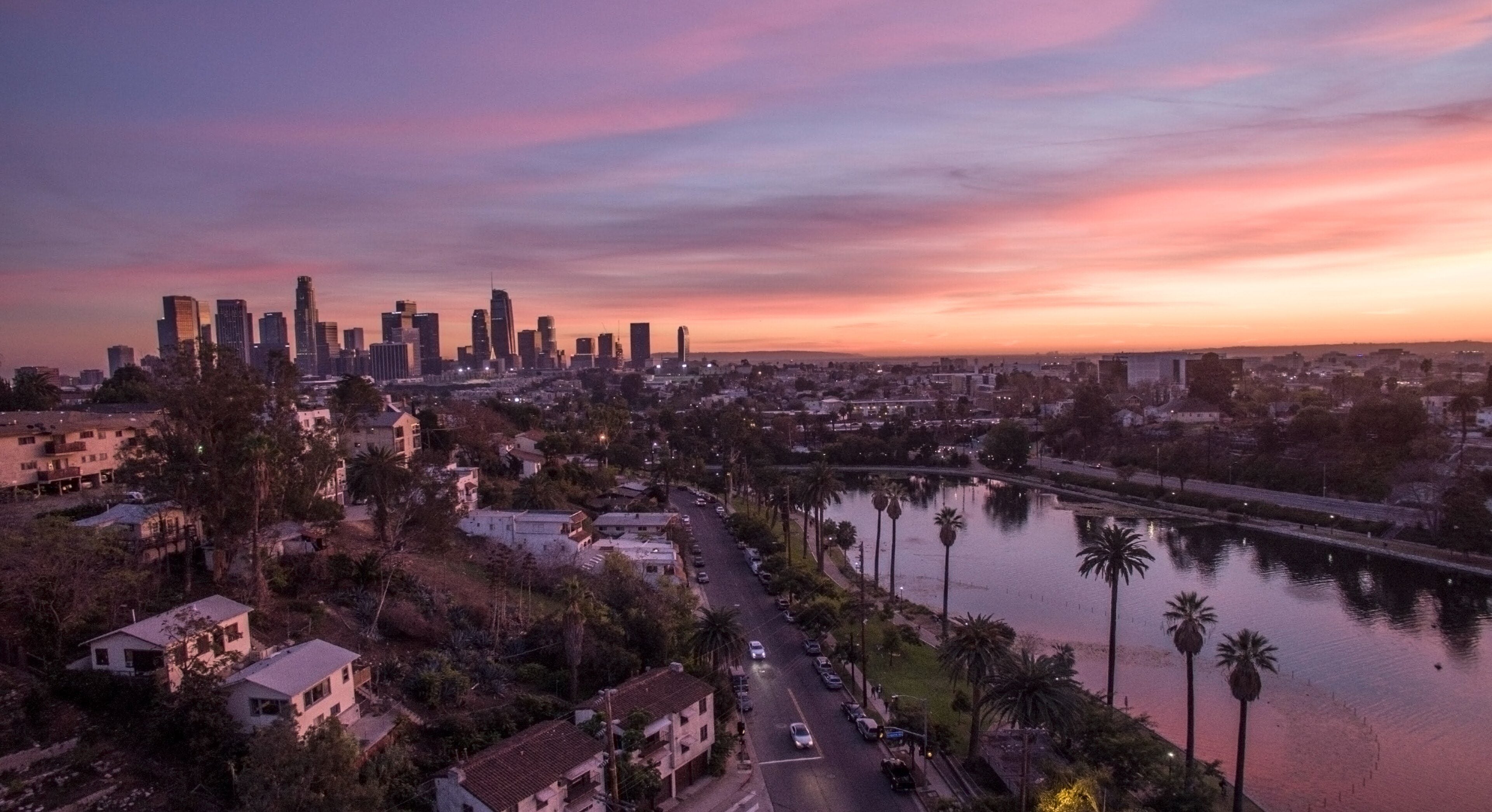 Echo Park Lake at dusk with the downtown skyline behind it