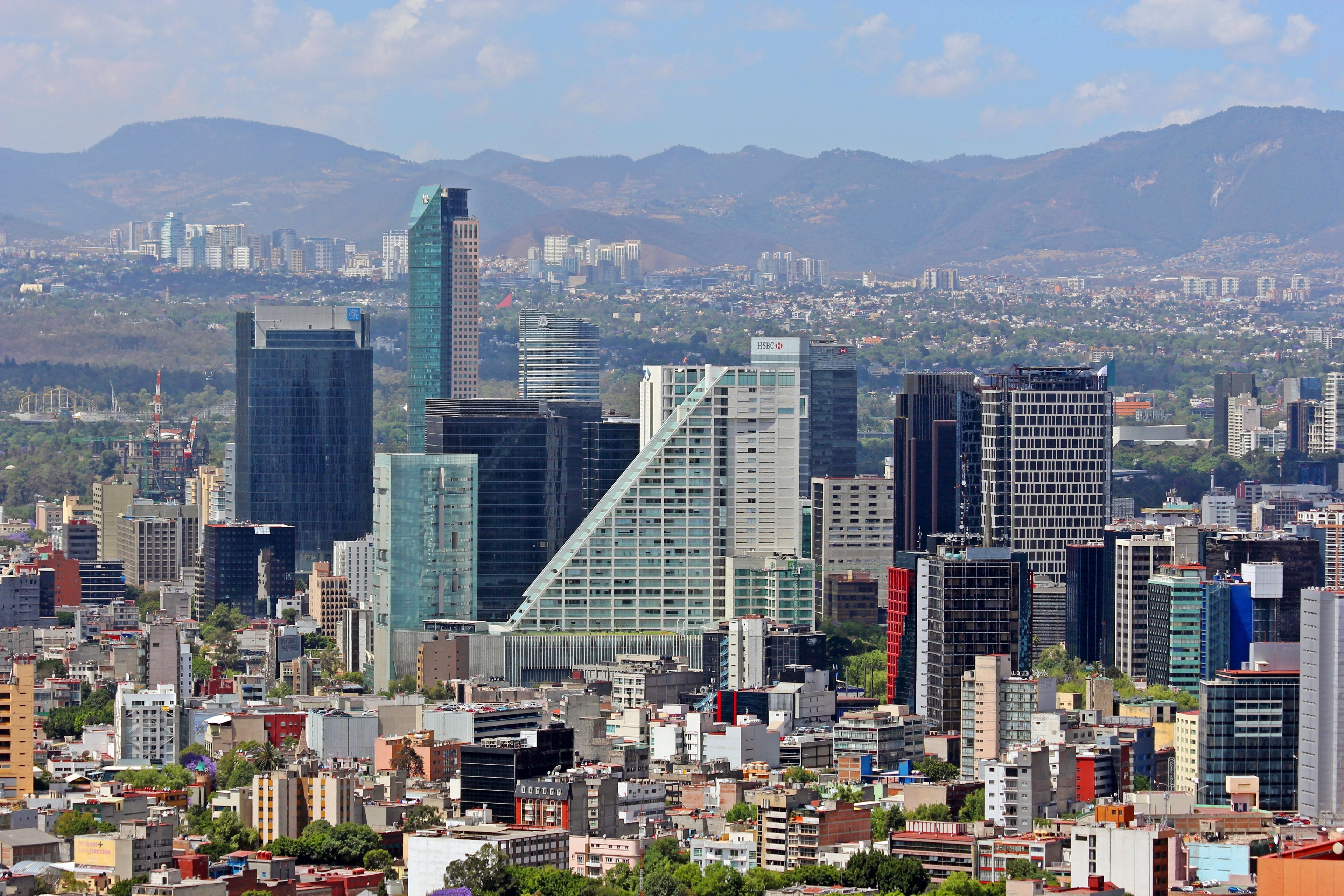 The Mexico City skyline along Paseo de la Reforma with mountains behind