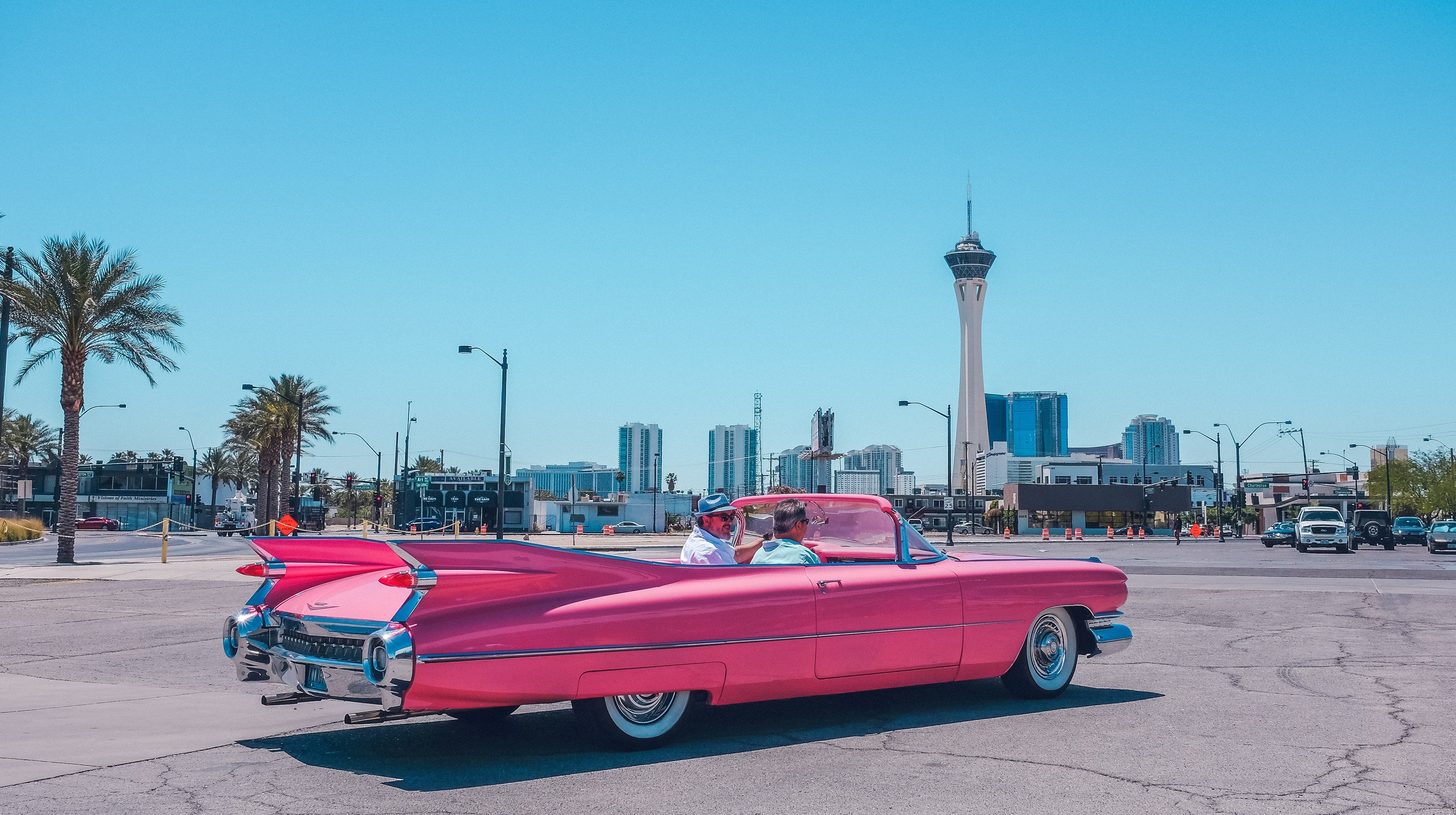 Pink 1950s Cadillac convertible parked in the Arts District with the Strat tower behind