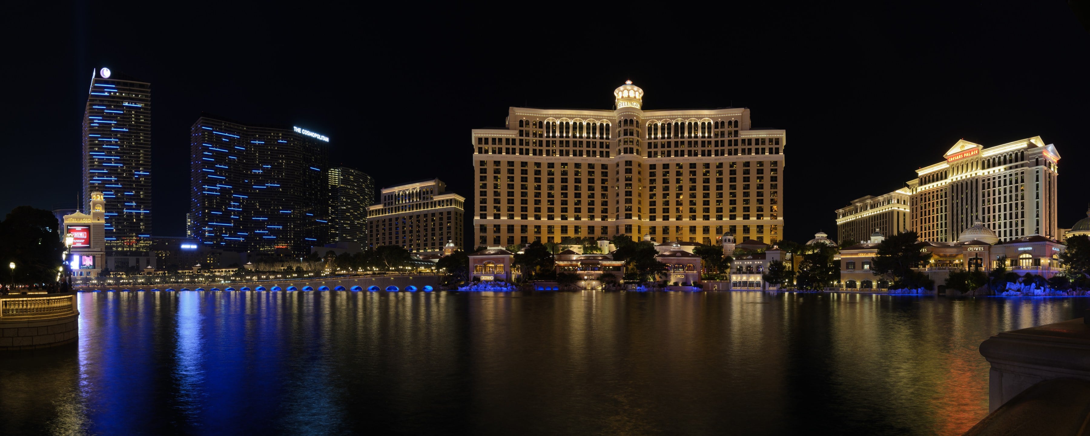 Bellagio and its lake at night, with Cosmopolitan towers to the left and Caesars Palace to the right