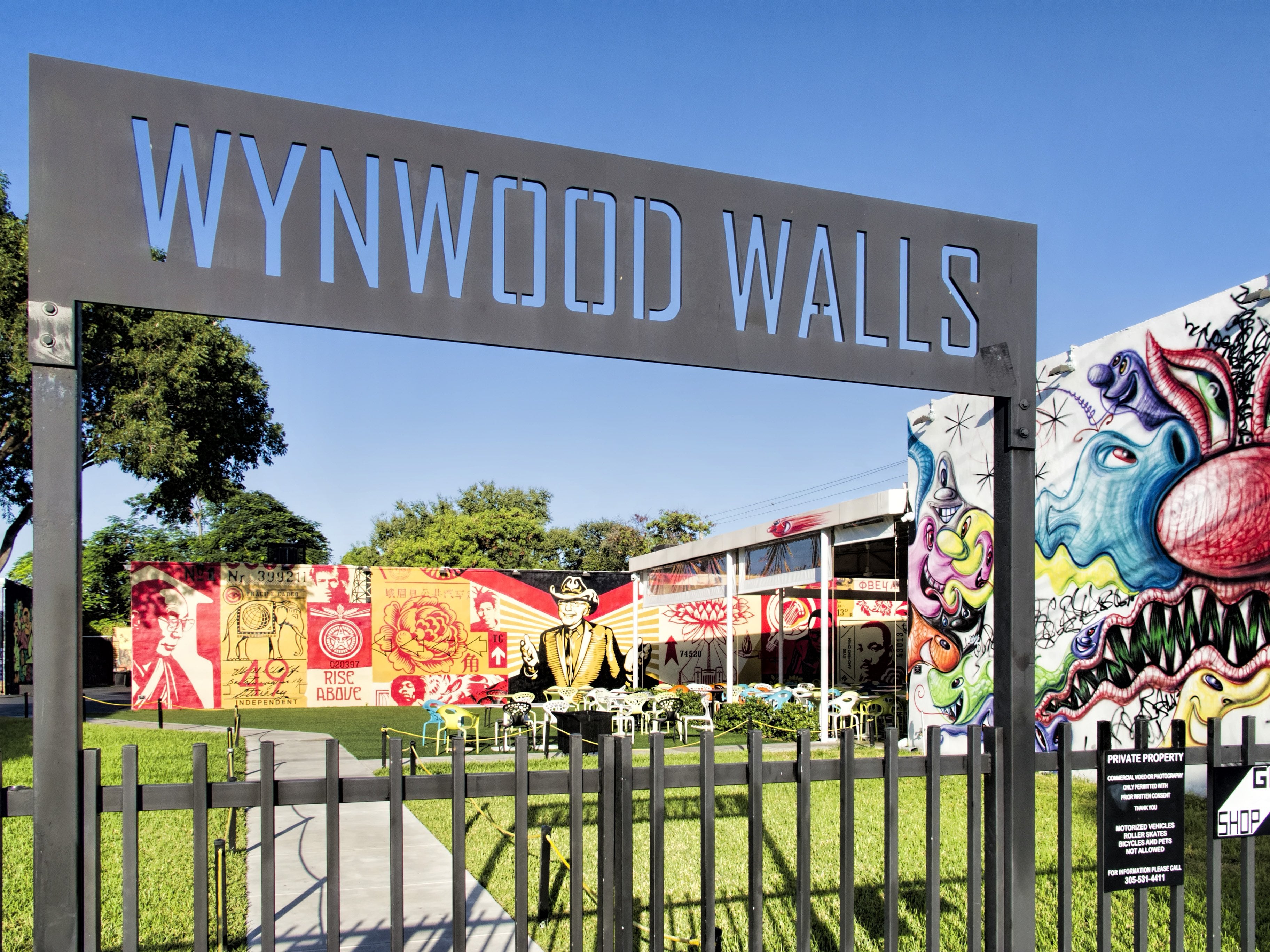 The Wynwood Walls entrance sign with murals behind the gate