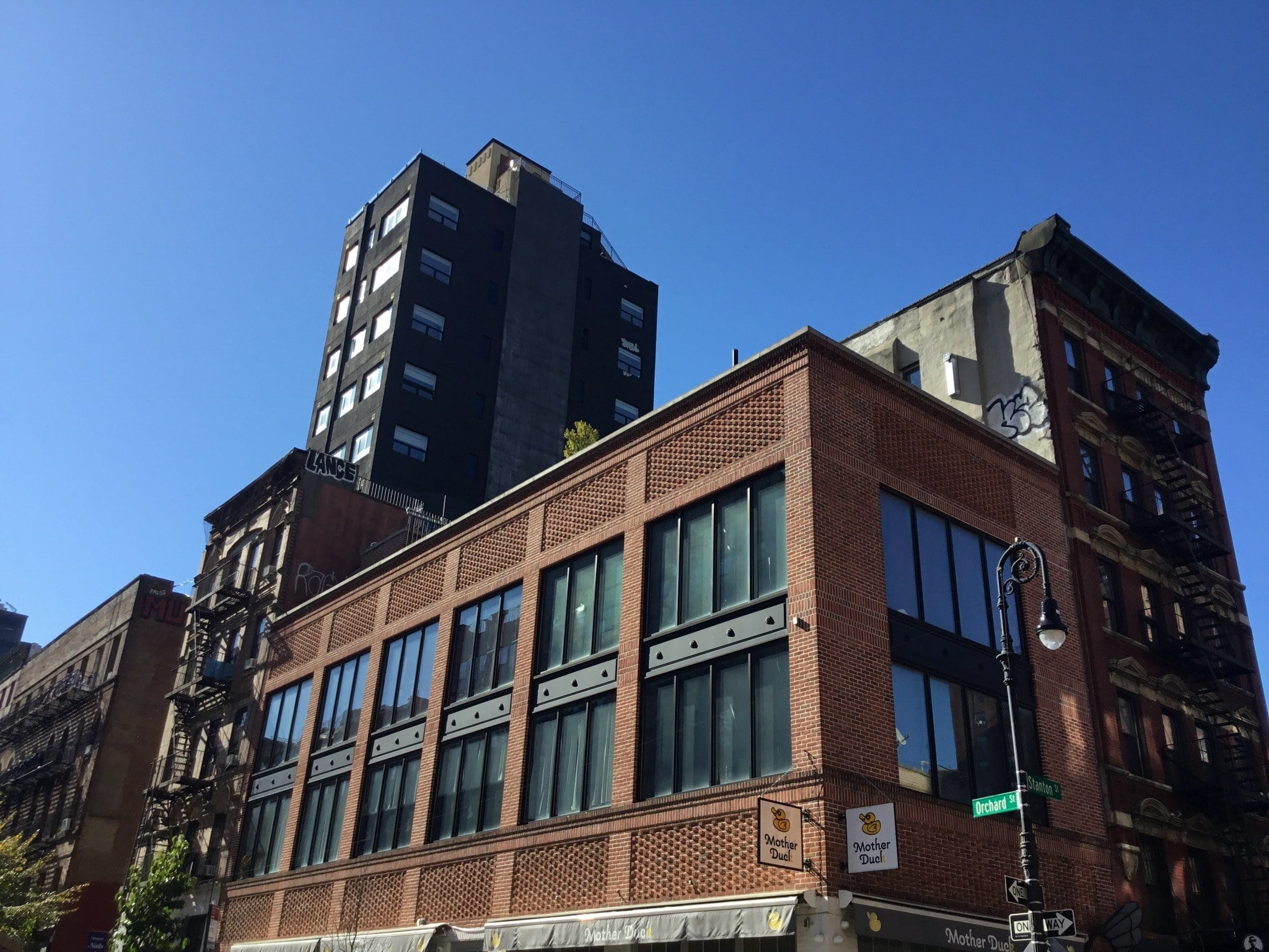 Red-brick Lower East Side buildings under deep blue sky