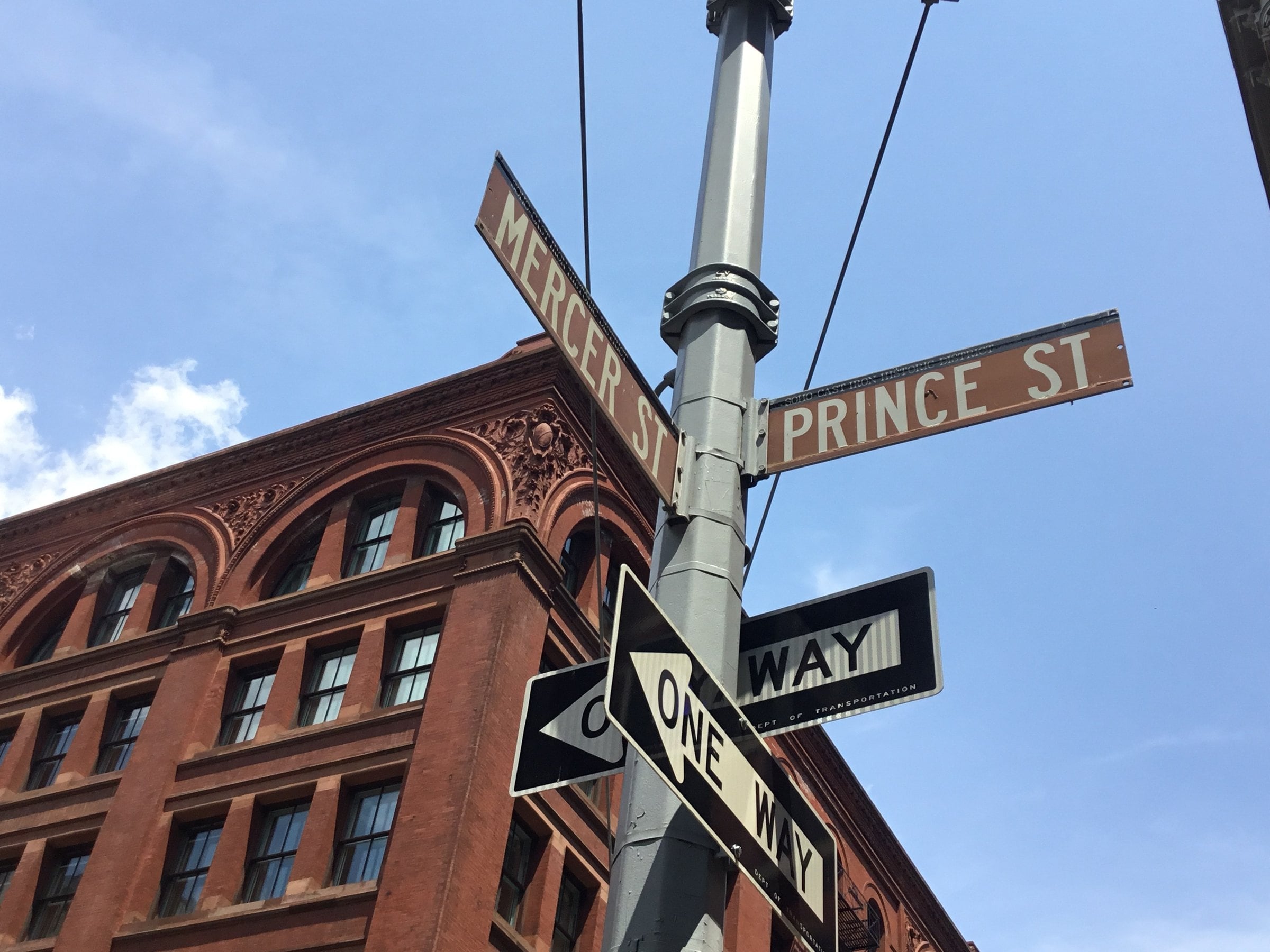 Prince Street and Mercer Street signs over red-brick SoHo facades