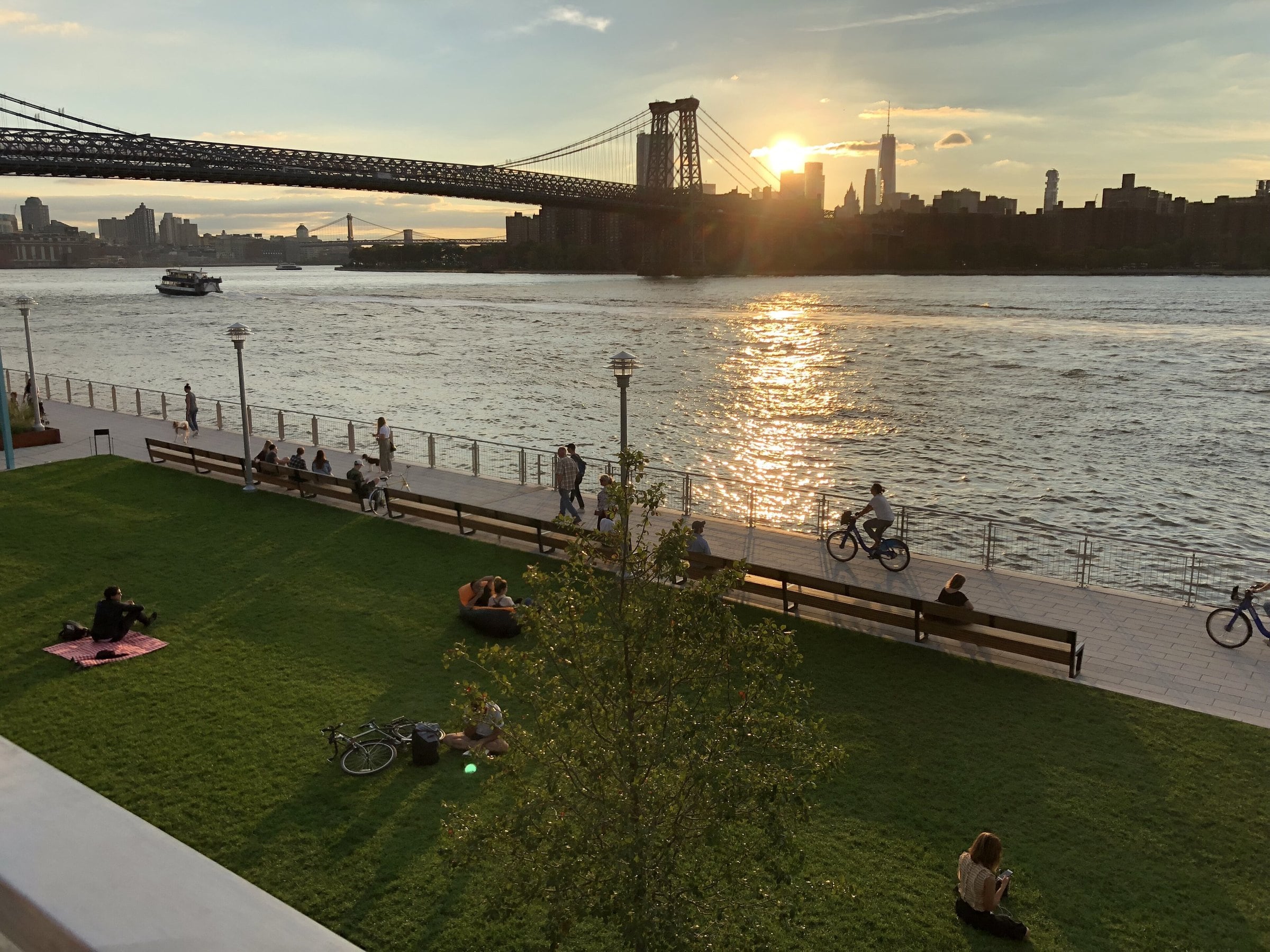 Sunset over the East River and Williamsburg Bridge from Domino Park lawn